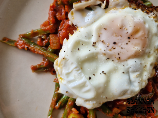 Twice cooked green beans in a rich tomato sauce topped with a fried egg
